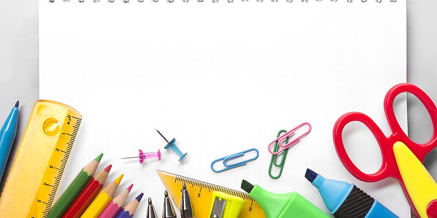 a drawing pad with scissors, pens, pencils, rulers, paper clips, markers, and thumb tacks