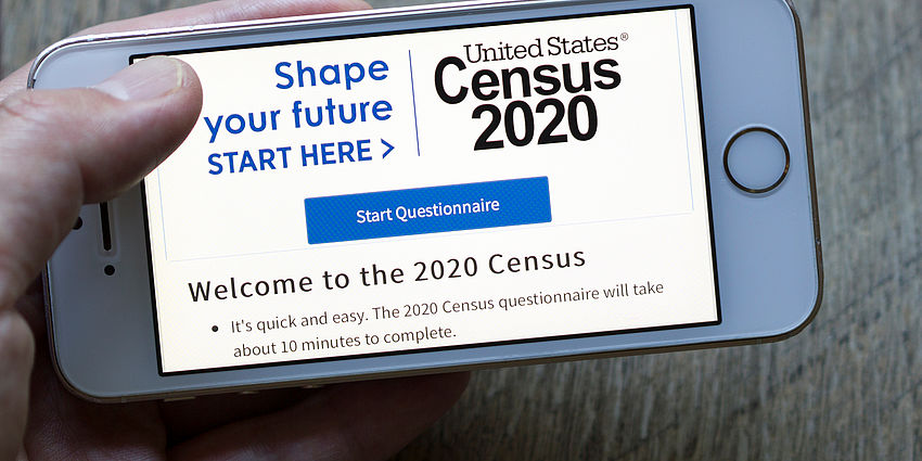 hand holding a smartphone with census page showing