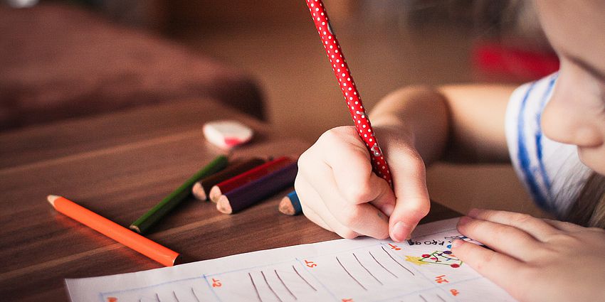 close up of a girl writing on a paper