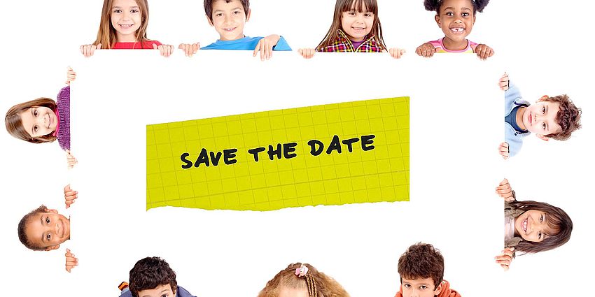 Students holding up a save the date sign.