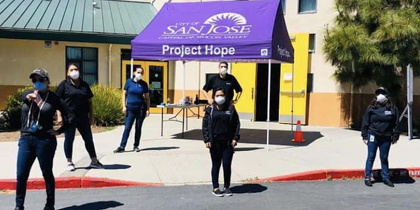 volunteers stand outside school