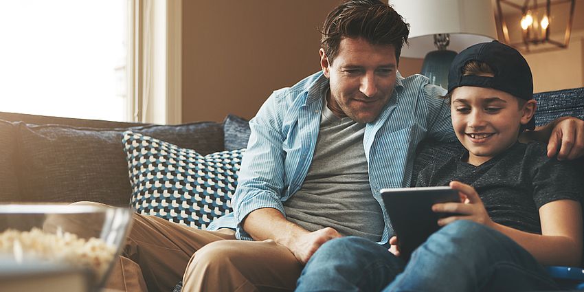 happy father and son together with digital tablet