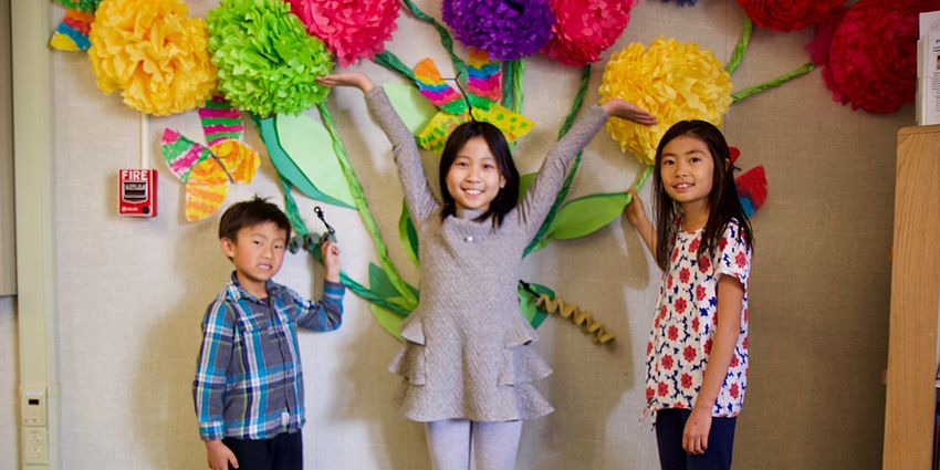 three students showing off wall art