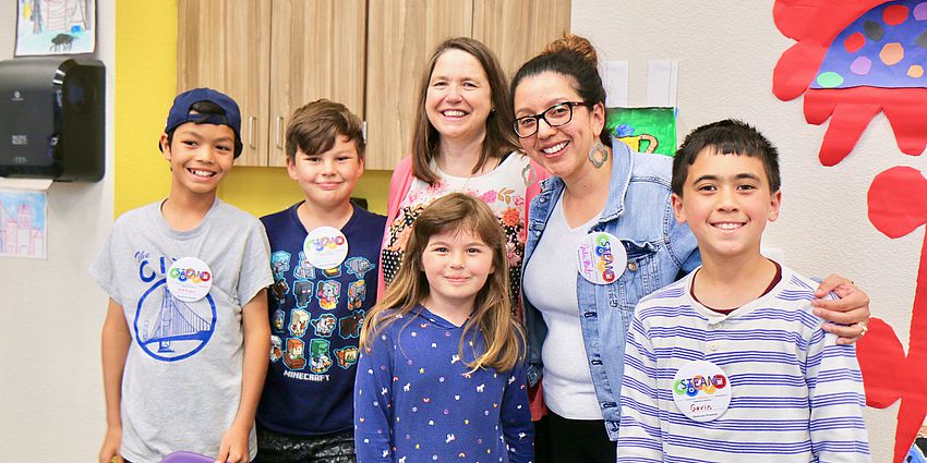 students and teachers smiling wearing STEAM pins