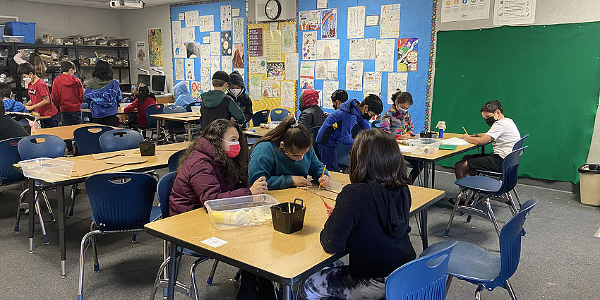 Students sitting at a table working on a STEM project