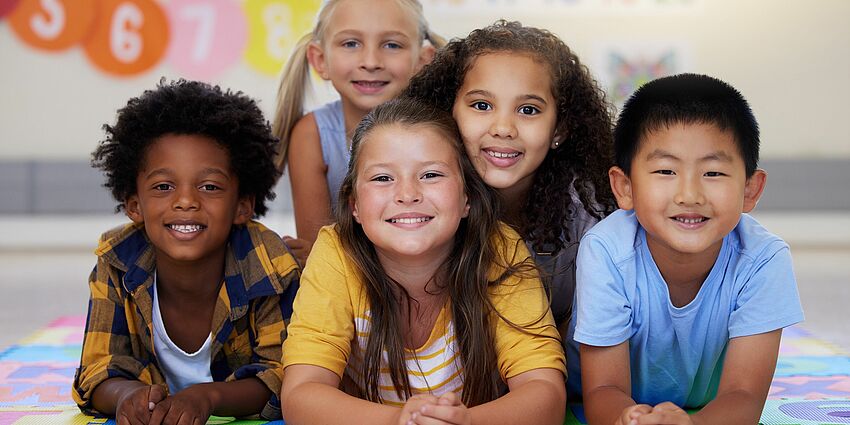 A happy group of 5 primary grade students of diverse ethnicities