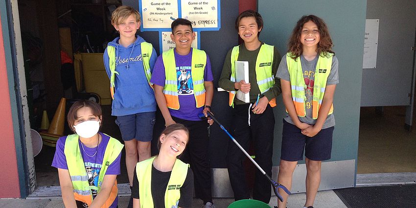 six elementary students in yellow vests smiling