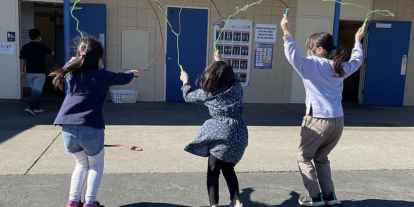 3 students jumping rope