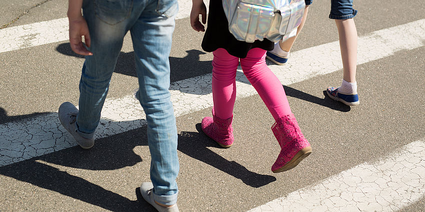legs/feet of children walking in crosswalk