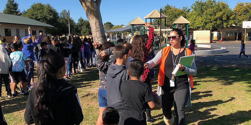 Students line up during a safety drill as staff members confirm who is present