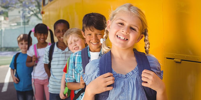 Children waiting in line to get on a bus.