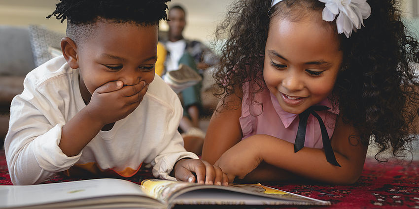 two children enjoying a book