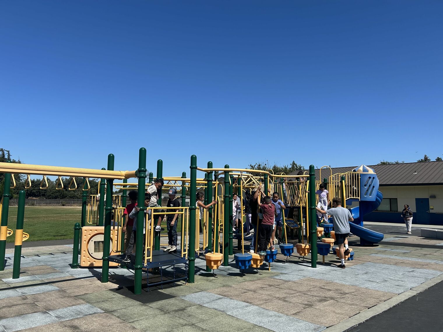 Children playing on a play structure at a school playground.