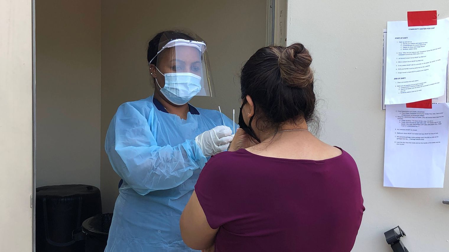 woman administering covid test to another woman